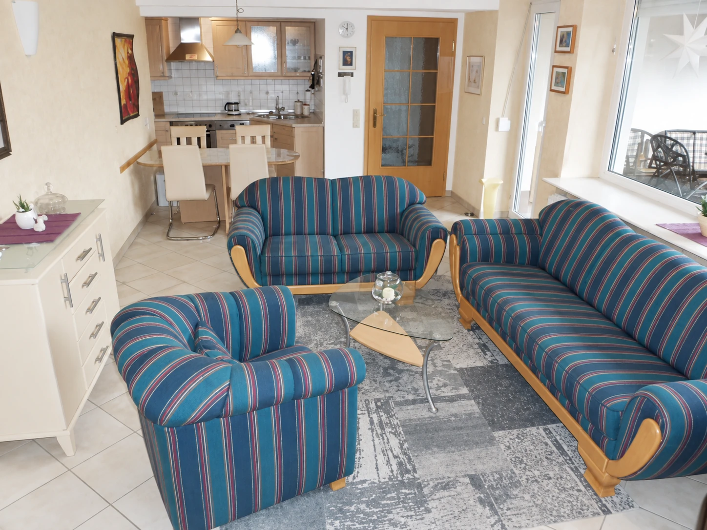 Wohn- und Essbereich mit Sofas, Esstisch und angrenzender Küche